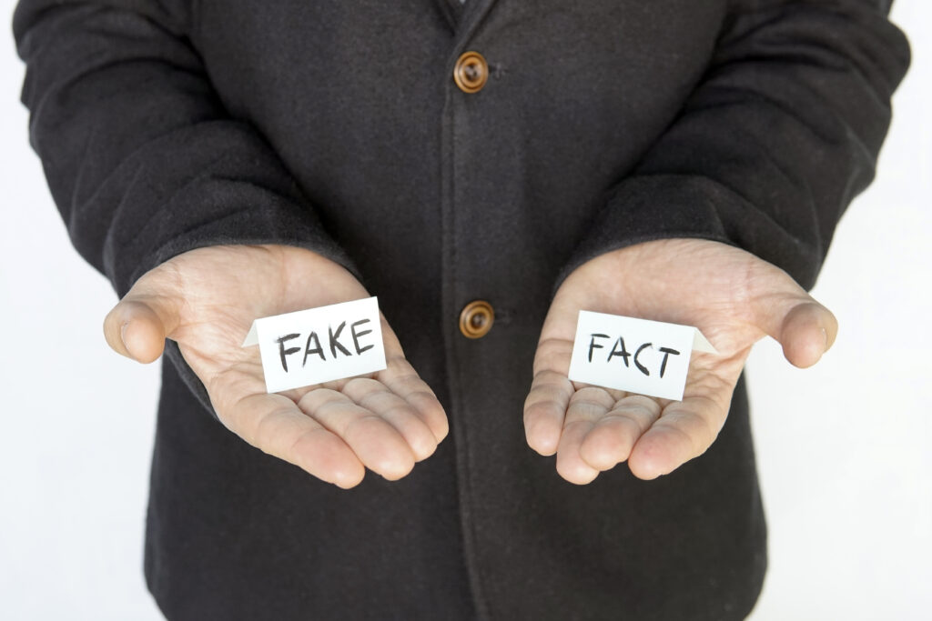 Fake o verdad? Imagen de una persona sosteniendo un papel con la palabra "falso" o "verdadero".